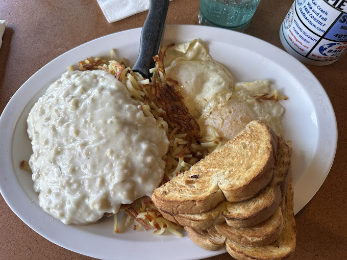 Chicken fried steak with country gravy on hash browns