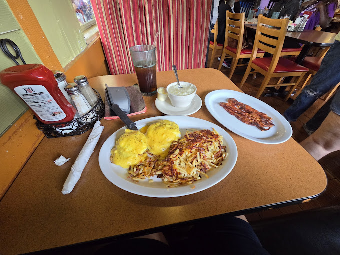 Eggs benedict with hash browns, bacon and tea